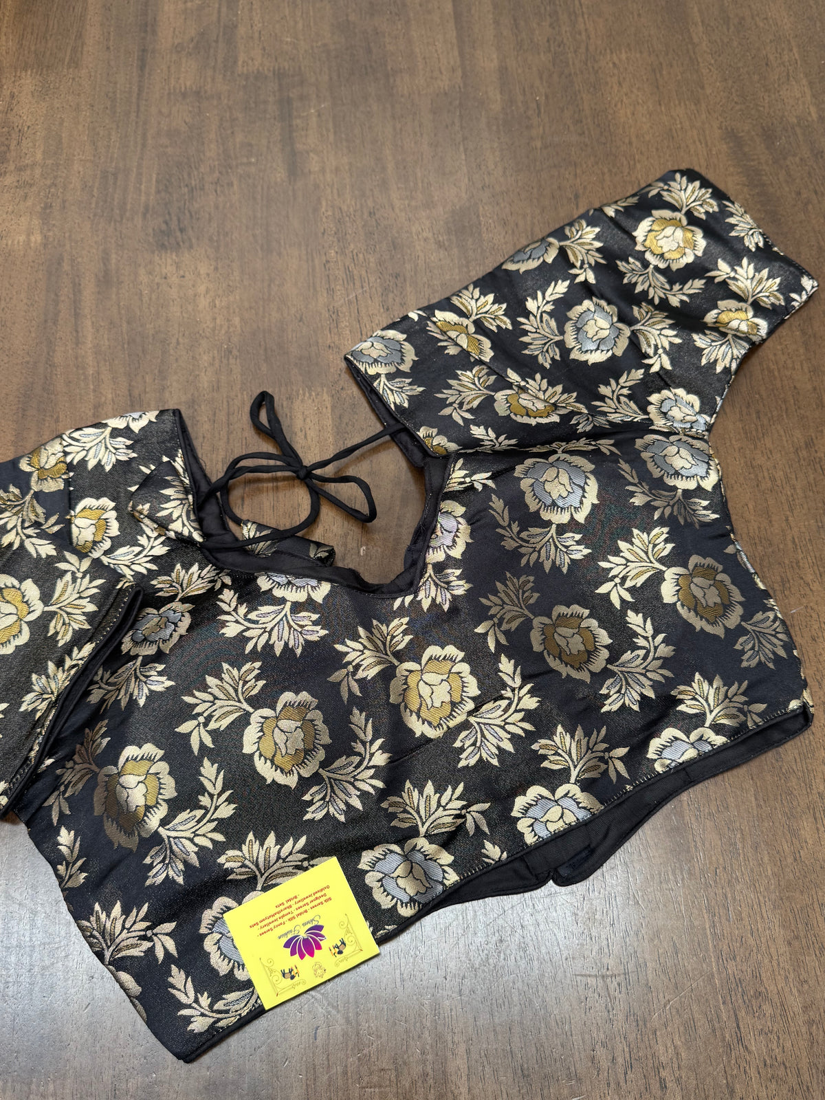 This elegant black floral brocade blouse adds soft shimmer and depth, making it a perfect match for silk, Banarasi, and Kanchipuram sarees.