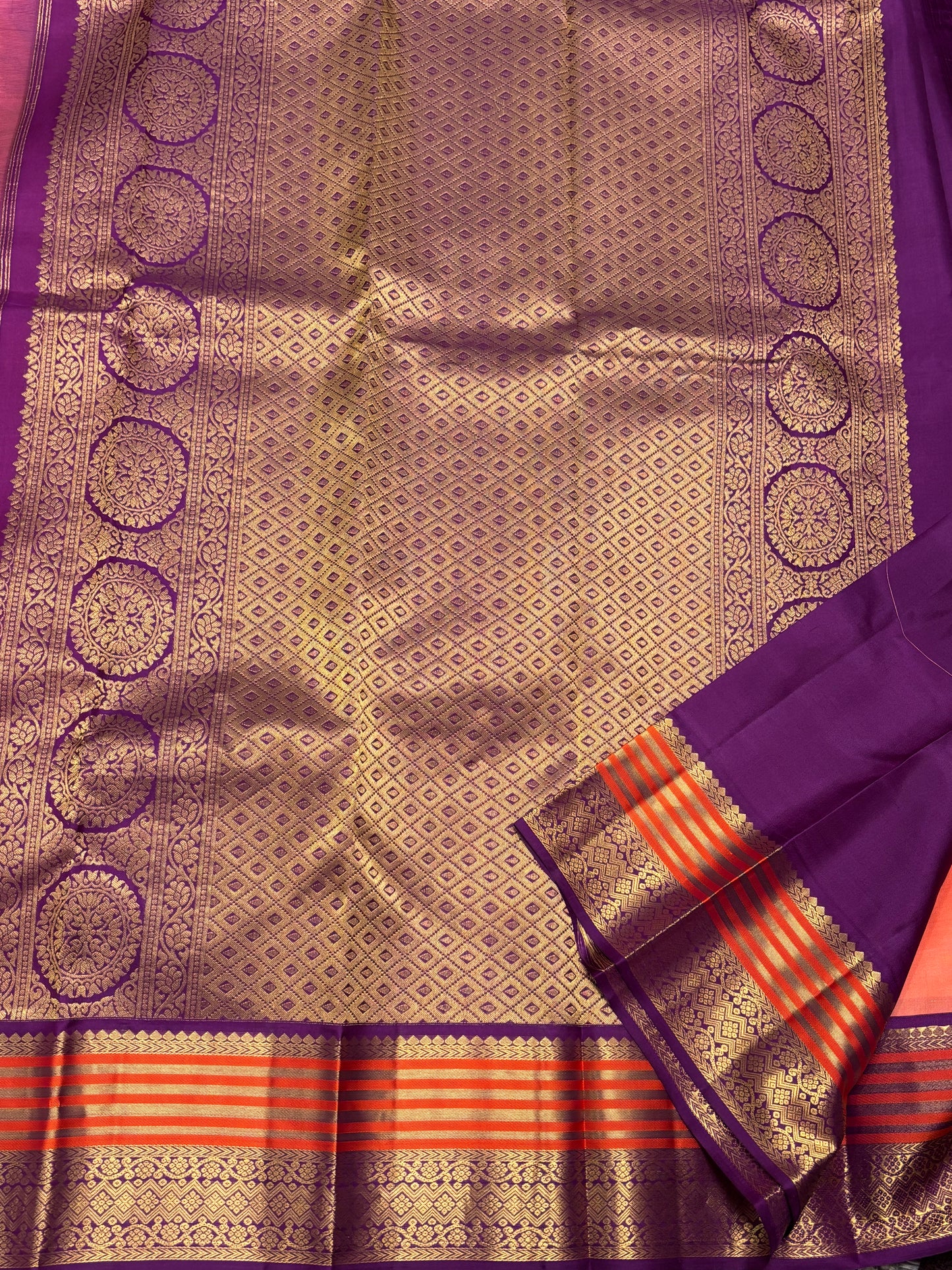 Elegant Peach‑Orange Silk Saree Featuring Classic Purple Highlights & Traditional Zari Accents