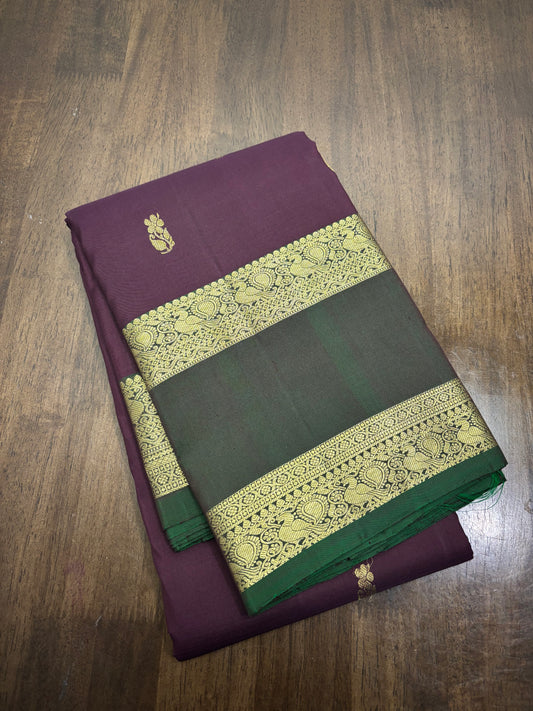 "Burgundy and green Kanchipuram silk saree with gold zari work displayed in full length, showing intricate border and pallu design"