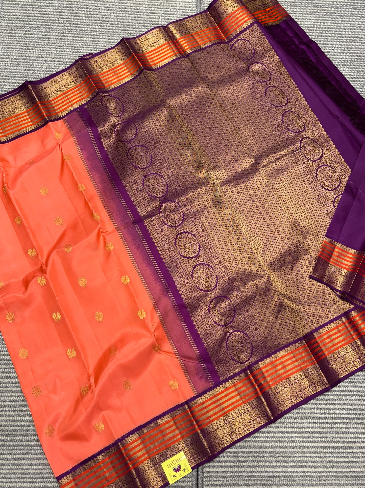 Elegant Peach‑Orange Silk Saree Featuring Classic Purple Highlights & Traditional Zari Accents