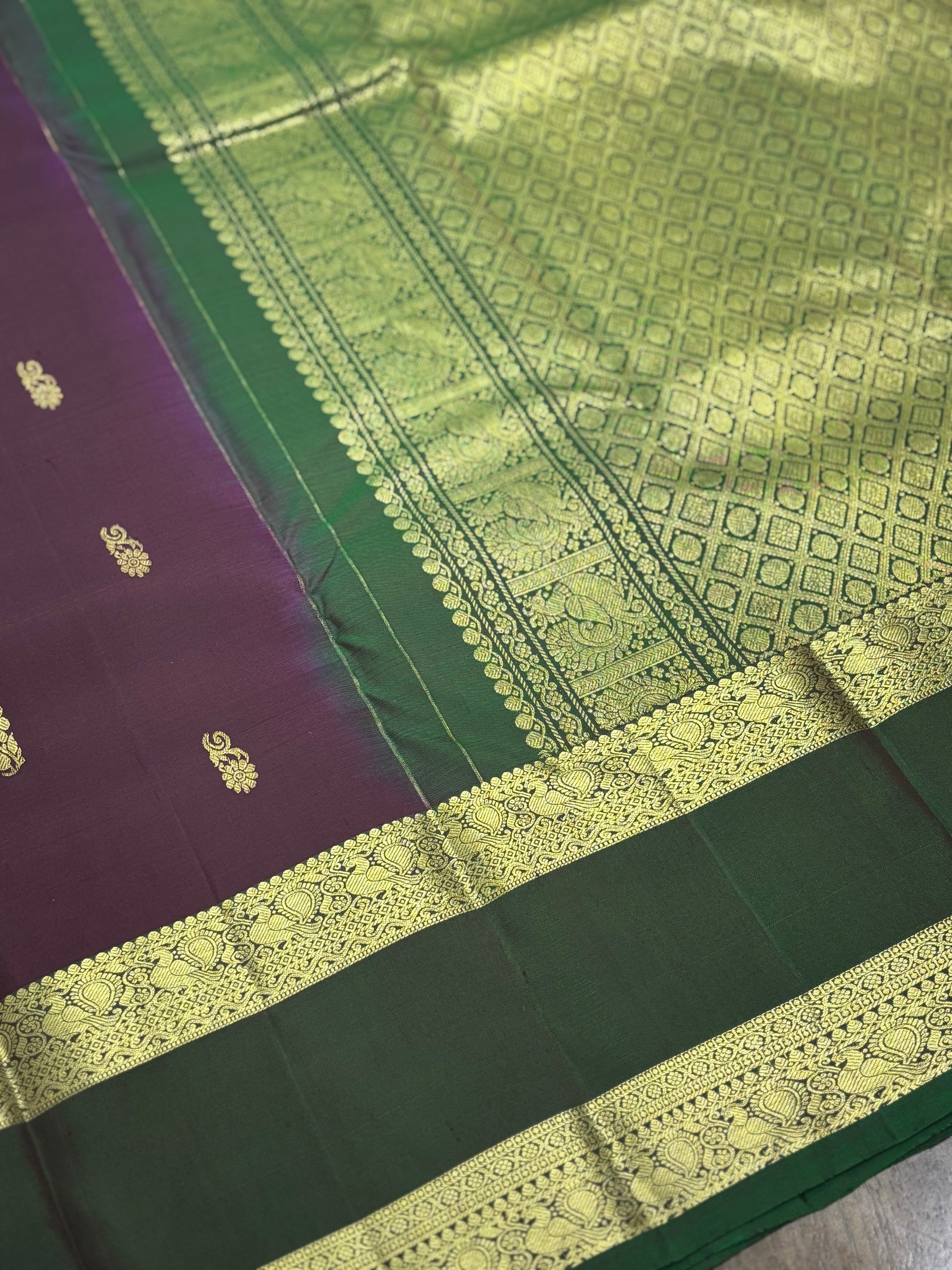 "Elaborate gold zari pallu design of burgundy Kanchipuram silk saree featuring traditional South Indian temple motifs"