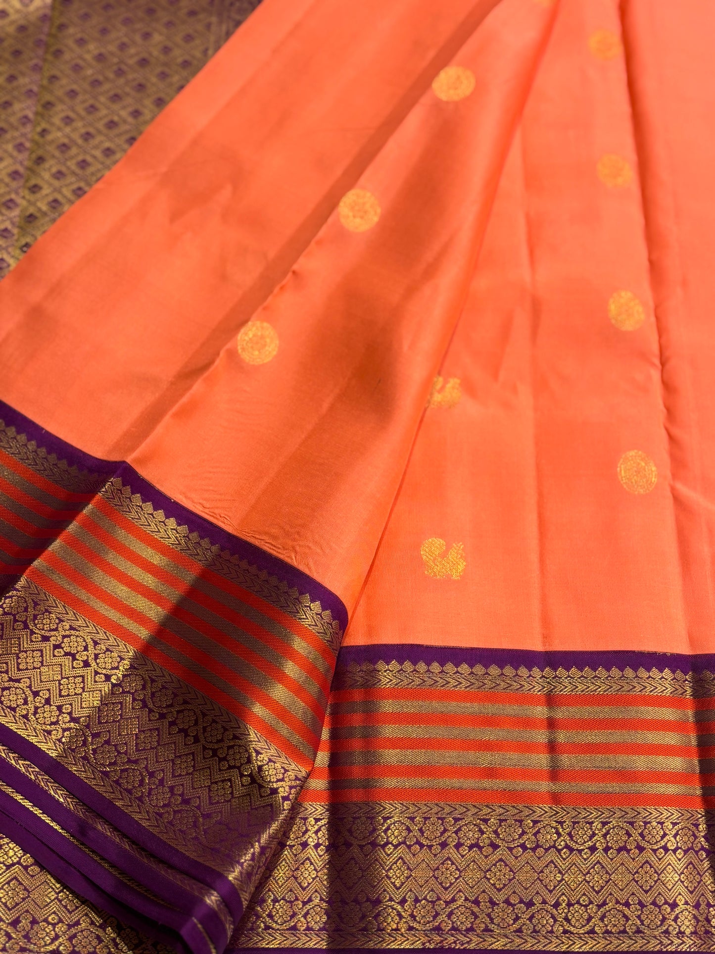 Elegant Peach‑Orange Silk Saree Featuring Classic Purple Highlights & Traditional Zari Accents