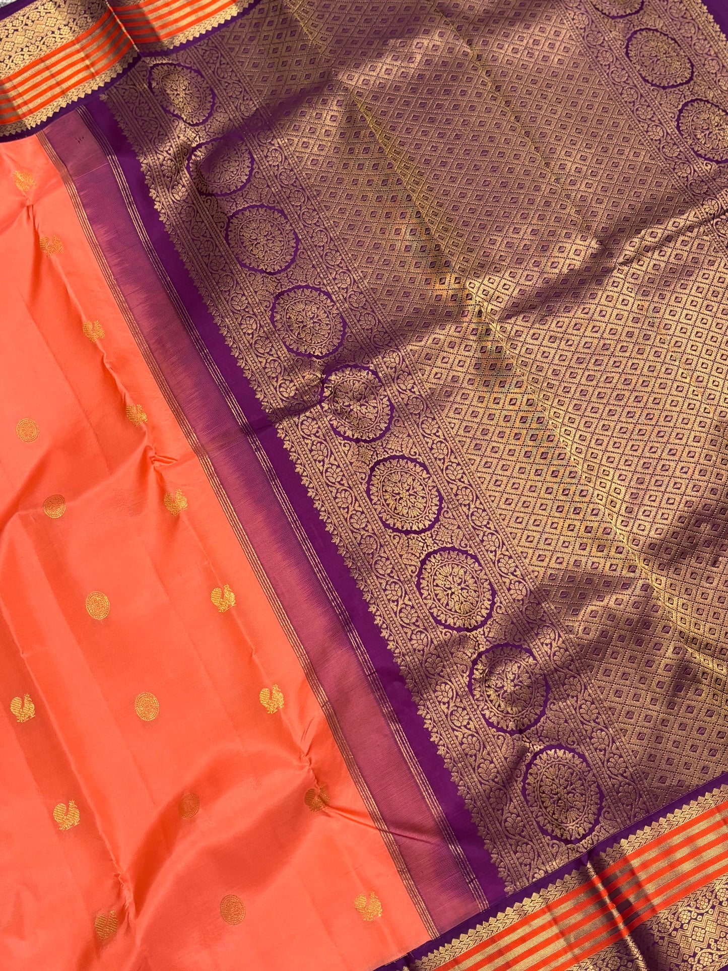 Elegant Peach‑Orange Silk Saree Featuring Classic Purple Highlights & Traditional Zari Accents
